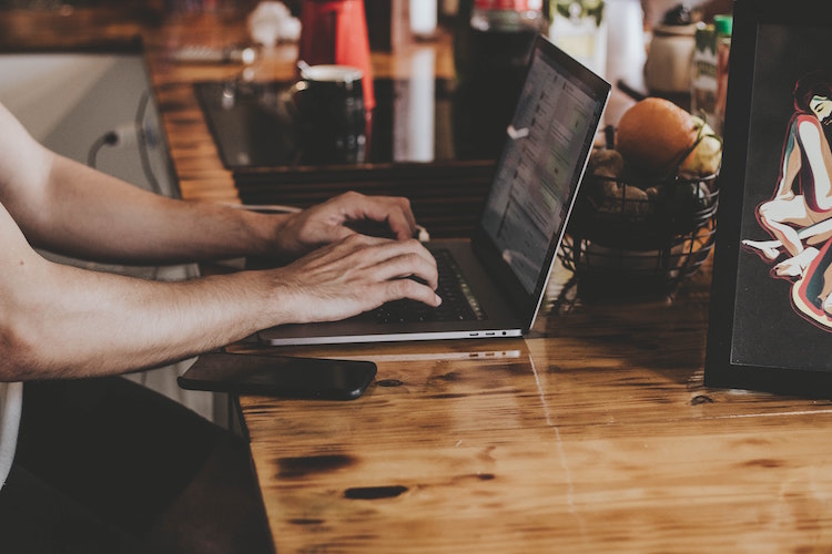 Someone typing on a laptop 